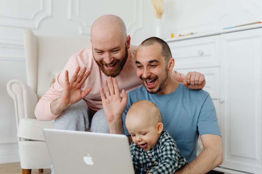 A family waving during a video call at home